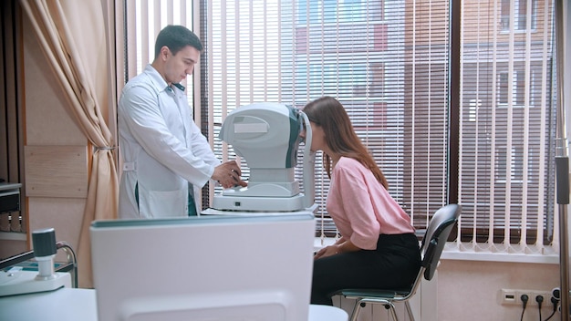 Traitement ophtalmologique jeune femme vérifiant son acuité visuelle avec un équipement spécial dans l'armoire spacieuse