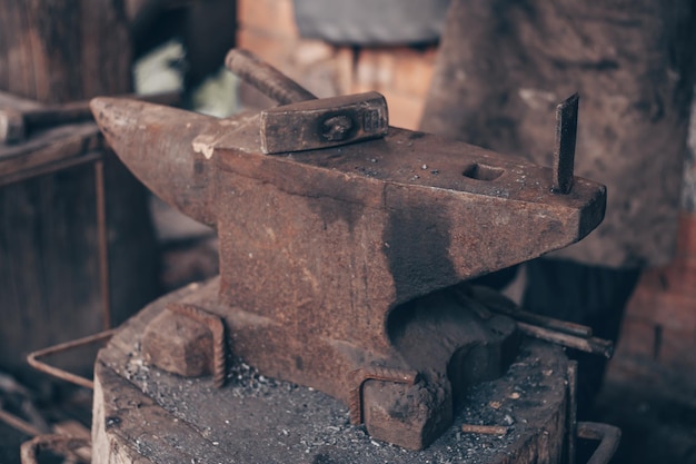 Traiter le métal avec un marteau sur l'enclume dans la forge Frapper le fer à l'extérieur dans l'atelier de forge métallurgique