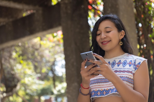 Traits indigènes de femme mexicaine utilisant une femme d'affaires de téléphone intelligent