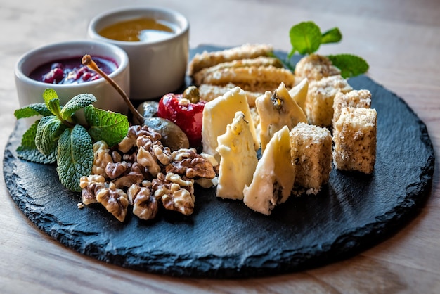 Tranchage de fromage différent avec des noix et des sauces