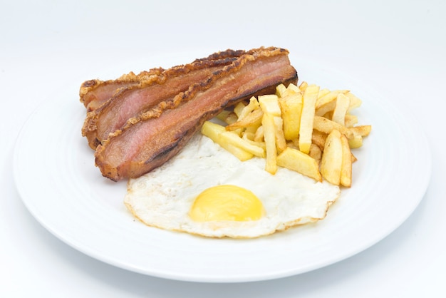 Tranche de bacon, oeuf et chips de pommes de terre en surface blanche