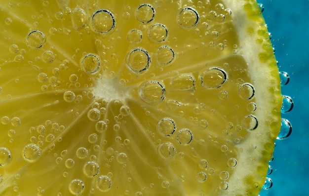 tranche de citron dans l'eau avec des bulles de gaz