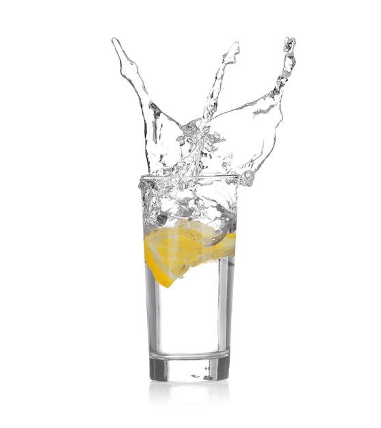 Tranche de citron frais tombant en verre avec de l'eau sur fond blanc