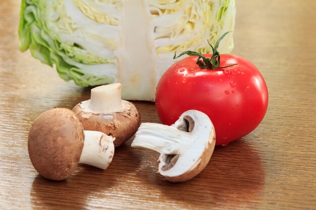 Tranché en demi chou frais, champignons et tomate rouge sur la table