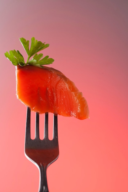 Une tranche de filet de saumon frais sur une fourchette