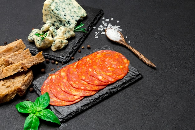 Tranche de fromage Roquefort et saucisse chorizo sur planche de service en pierre