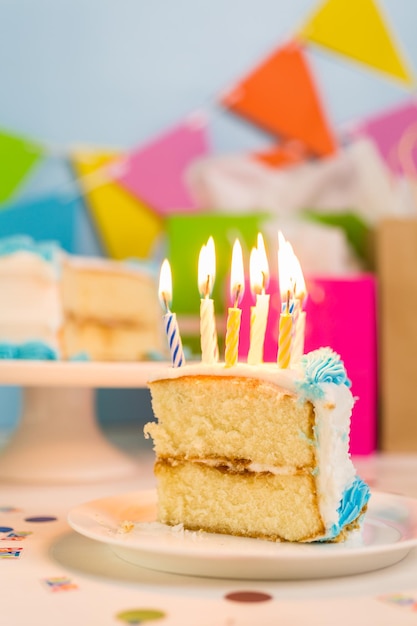 Tranche de gâteau d'anniversaire blanc simple avec glaçage blanc et bleu.