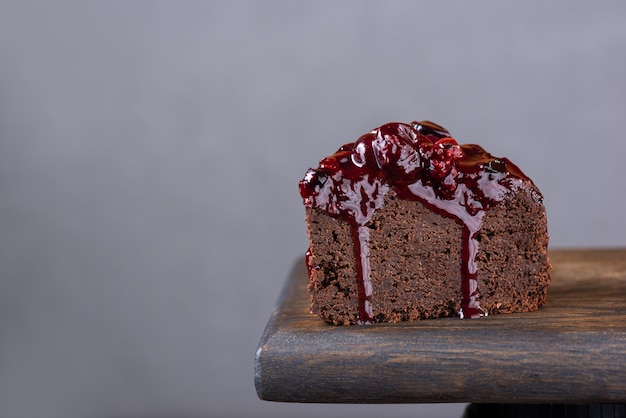 Tranche de gâteau au chocolat aubergine avec confit de cassis sur une planche en bois