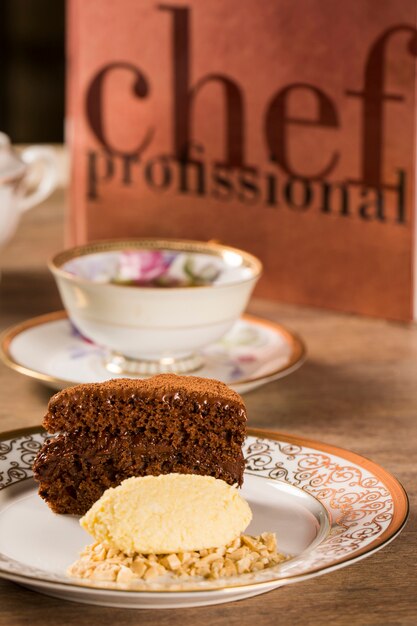 Une tranche de gâteau au chocolat riche avec de la crème glacée et du café sur la table