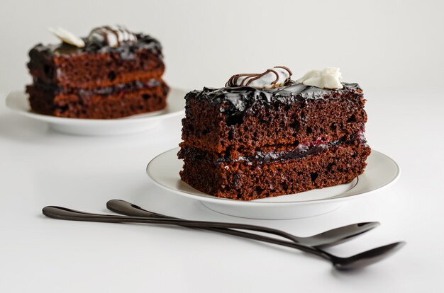 Tranche de gâteau au chocolat sucré sur fond blanc