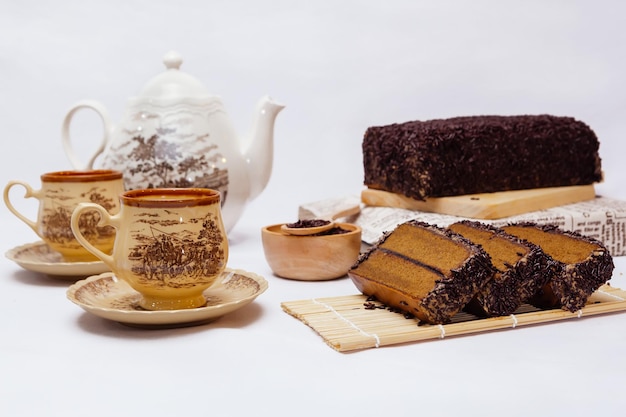 Tranche de gâteau au chocolat avec une tasse de thé sur bois