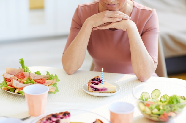 Tranche de gâteau au fromage avec bougie allumée