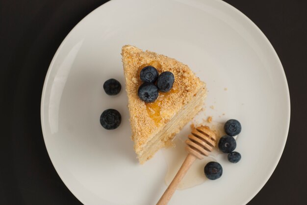 Tranche de gâteau au miel fait maison avec des myrtilles.