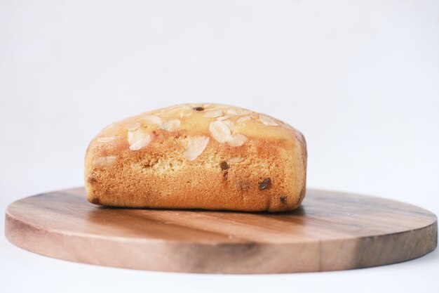 Tranche de gâteau de boulangerie sur planche à découper sur blanc