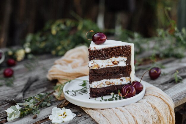 Tranche de gâteau décoré de cerise sur une table en bois