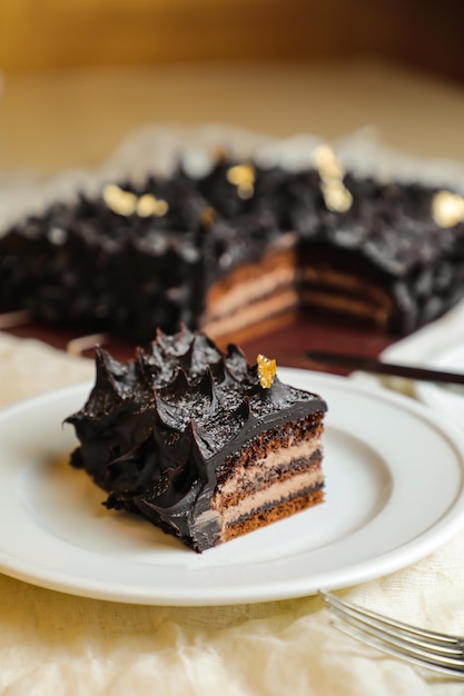 Tranche de gâteau Ganache au chocolat servie dans une assiette avec un couteau isolé sur une serviette, vue sur le dessus de la nourriture cuite au café