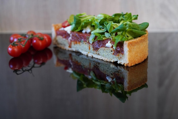 Tranche de gâteau de légumes se trouvant sur la surface du miroir noir. Concept de cuisine saine.