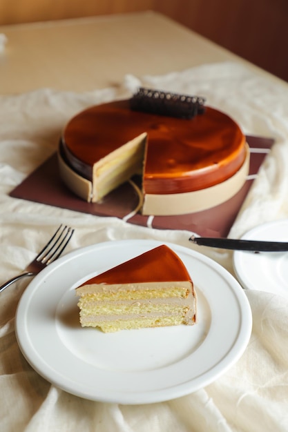 Photo la tranche de gâteau mocha comprend du sucre à la crème au chocolat avec couteau et fourchette servi dans l'assiette vue latérale de la nourriture du café