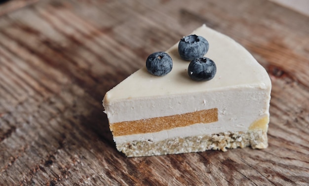 Tranche de gâteau sans gluten avec gros plan de bleuets sans sucre sur un fond en bois Cuisson au lait d'amande