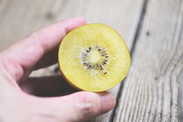 Tranche de kiwi sur bois, kiwi à la main