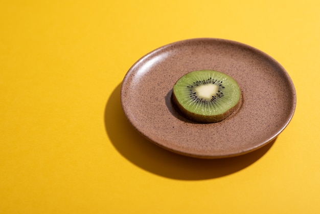 Photo une tranche de kiwi pousse à partir d'un plat en céramique sur une surface plane