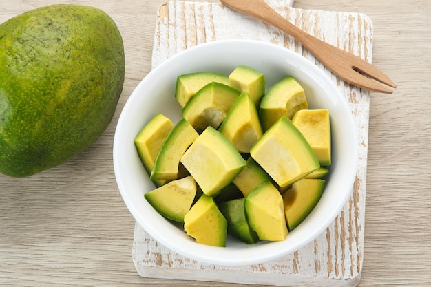 Une tranche de mangue fraîche et mûre sur un bol en bois