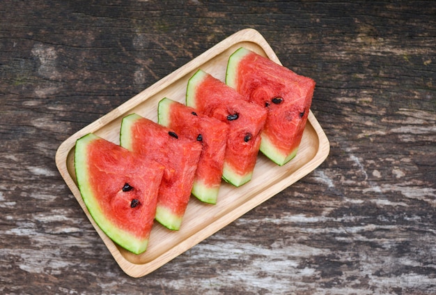 Tranche de melon d'eau fraîche - fruit tropical de melon d'eau sur un plateau en bois, vue de dessus