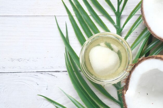 Tranche De Noix De Coco Fraîche Et Bouteille D'huile Sur Une Table