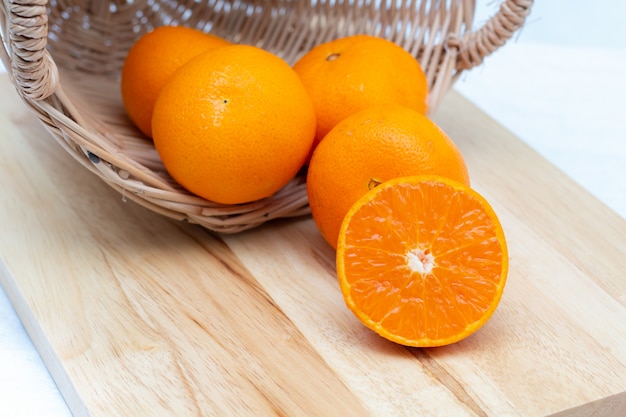 Tranche d'orange dans un panier sur fond de bois,