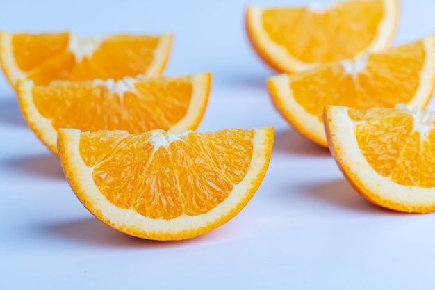 Tranche d'oranges sur la surface blanche.