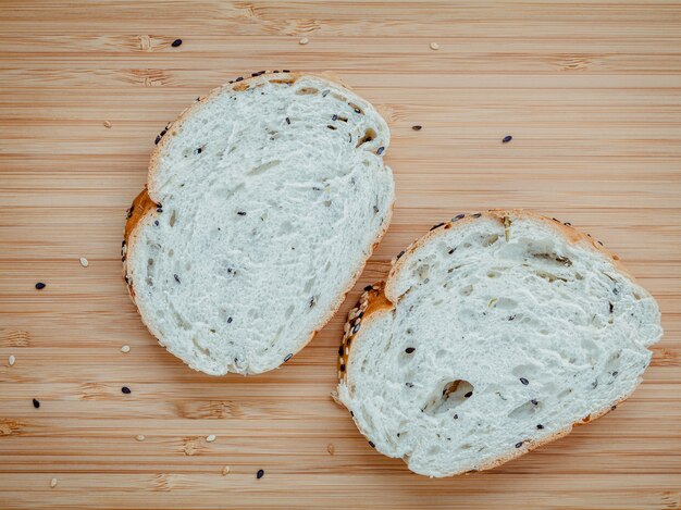 Tranche de pain aux herbes fraîches faites maison sur planche à découper en bambou.