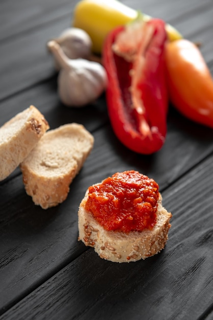 Une tranche de pain enduite de chutney sur une table en bois