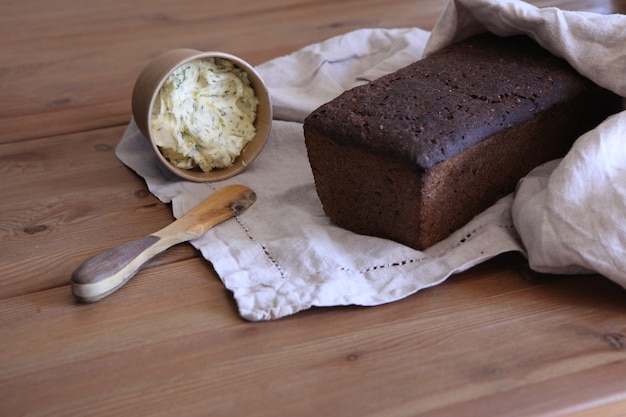 Photo tranche de pain frais et couteau en bois de coupe sur table rustique. pain fait maison