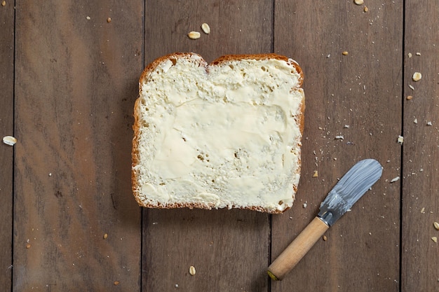 Tranche de pain miche avec de la margarine sur un bureau en bois