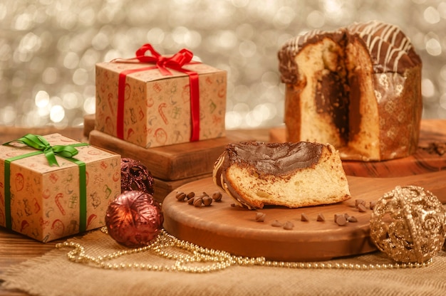 Tranche de panettone au chocolat sur une planche à découper en bois avec des ornements de Noël