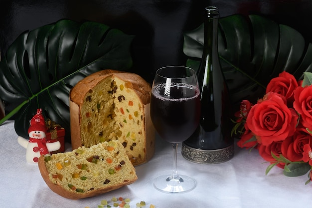 tranche de panettone verre de vin rouge une bouteille de vin sur une table avec une nappe blanche et Christm