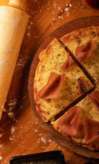 tranche de pizza avec du fromage et du jambon au premier plan