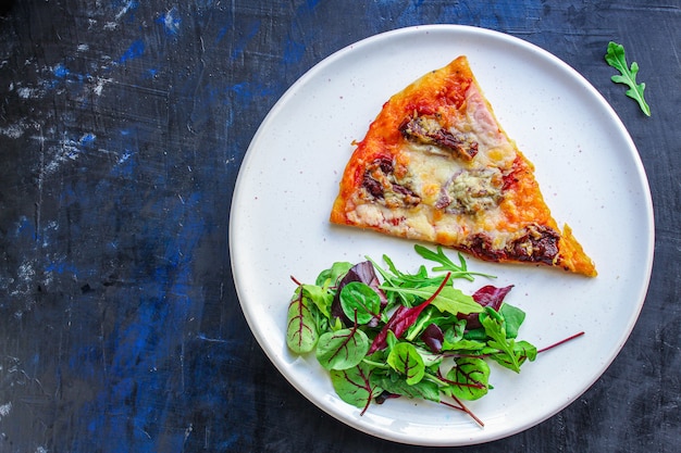 tranche de pizza et feuilles de salade dans une assiette