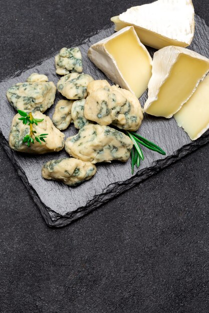 Tranche de roquefort français et fromage brie sur planche de pierre