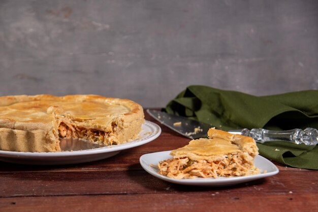 Photo une tranche de tarte au poulet sur un fond en bois rustique