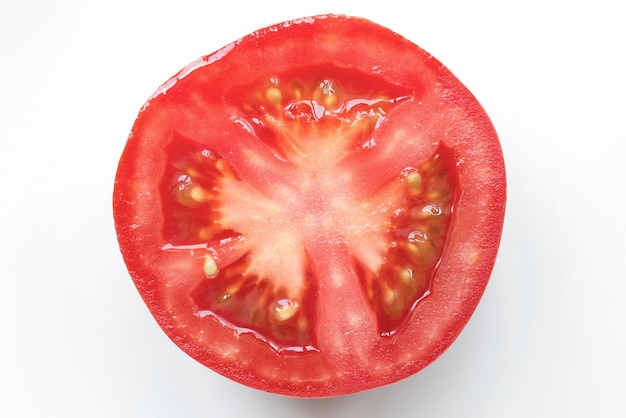 Tranche de tomate juteuse fraîche isolée sur blanc