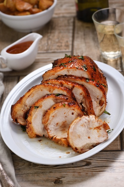 Tranché en tranches de poitrine de dinde cuite au four sous une sauce aigre-douce à la table du dîner