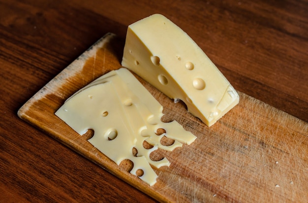 Trancher le fromage sur une planche de bois.