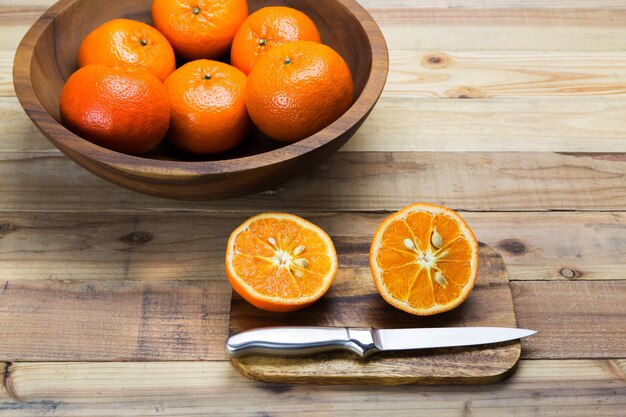 Trancher les oranges sur fond en bois.