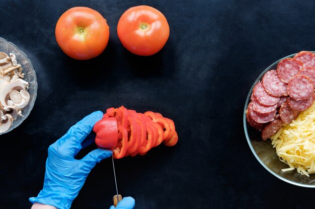 Trancher la tomate et les ingrédients dans la cuisine, vue du dessus