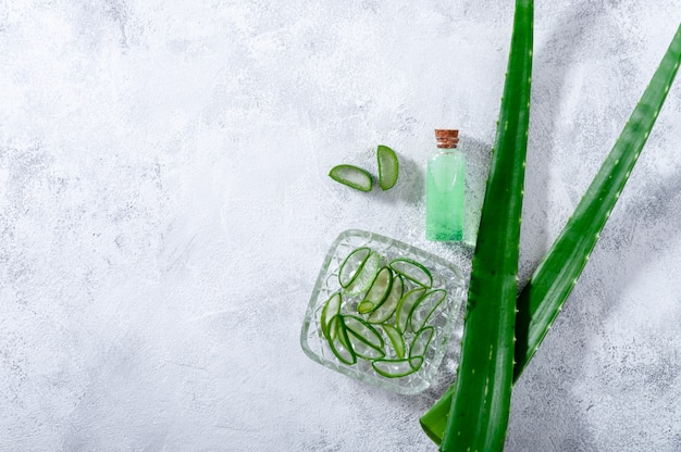 Tranches d'Aloe Vera, feuilles et pot avec jus d'Aloe Vera.