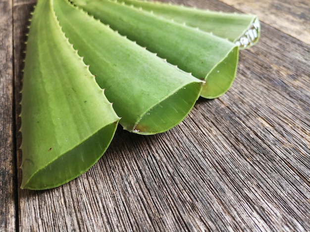 Tranches d'aloe vera sur table rustique en bois.