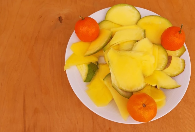 Tranches d'ananas et de clémentines dans un fond en bois de plaque