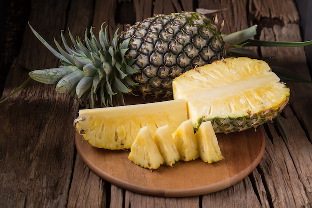 Tranches d&#39;ananas mûrs et d&#39;ananas sur un fond en bois fruits tropicaux