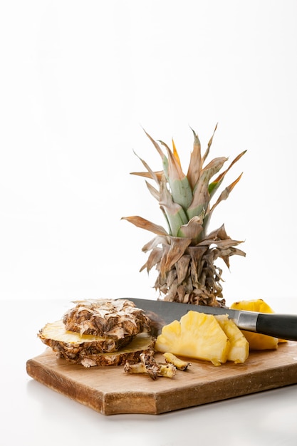 Tranches d'ananas tranchées au couteau sur un plateau de cuisine